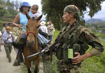 Un soldado del Ejército observa como desplazados abandonan sus tierras. (Fernando VERGARA/AFP PHOTO)