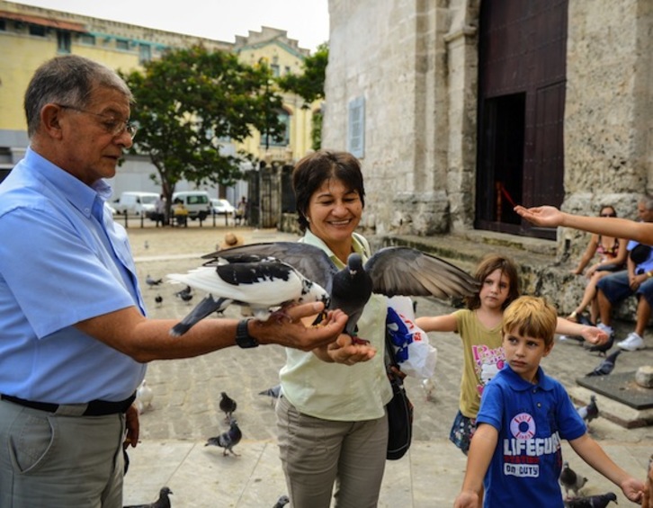 Rodrigo Granda juega con palomas en La Habana, acompañado por Sandra Ramírez, viuda de Manuel Marulanda. (Adalberto ROQUE/AFP PHOTO)