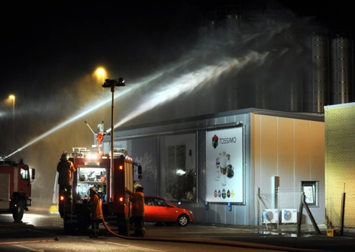 Los bomberos tratan de controlar la fuga tóxica con agua en Kraft Foods. (Ingo WAGNER/AFP)