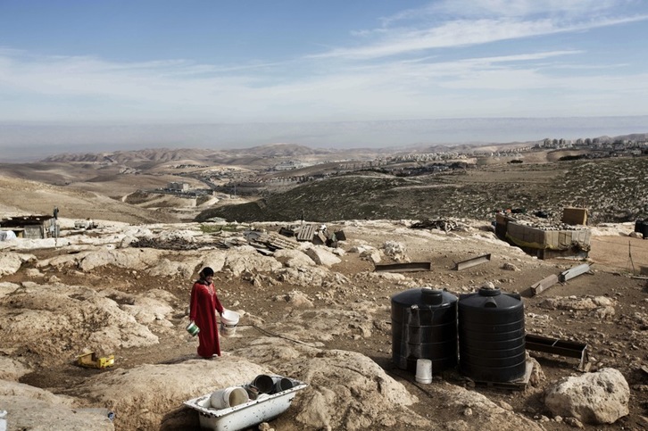 Una mujer camina en el área E1, entre Jerusalén y Cisjordania, donde el Gobierno israelí tiene previsto construir viviendas. (Menahem KAHANA/AFP) 