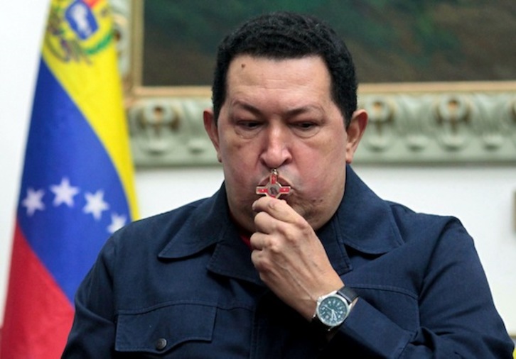 Imagen difundida por Presidencia venezolana que muestra a Chávez besando un crucifijo el pasado sábado, cuando anunció que padece cáncer. (AFP)