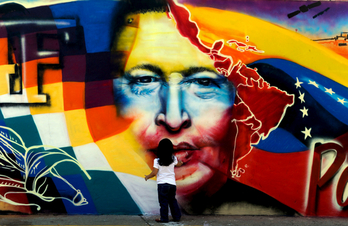Un niño se pone delante de un graffiti de Chávez. (Juan BARRETO/AFP)
