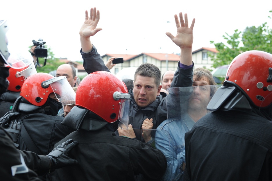Un trabajador, con las manos en alto, frente al muro de la Ertzaintza. (ARGAZKI PRESS)
