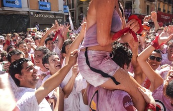 Varios hombres intentan quitar la ropa a una joven subida a hombros de un joven. (Jagoba MANTEROLA/ARGAZKI PRESS)