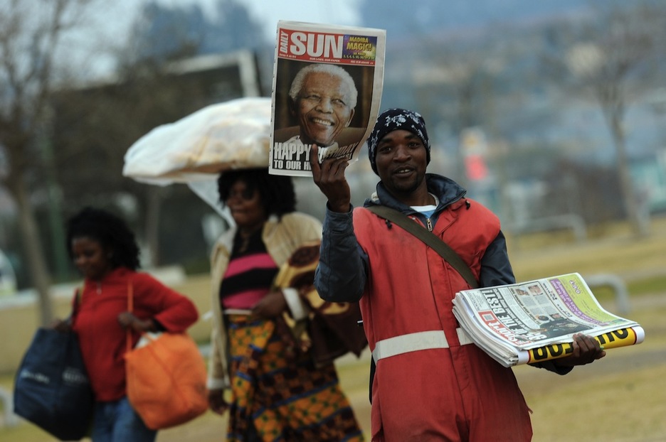 Vendedor de periódicos en Soweto (Alexander JOE / AFP)