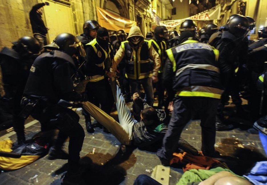 Agentes de la Policía española arrastran a una persona por la plaza Nabarreria. (Jagoba MANTEROLA/ARGAZKI PRESS)