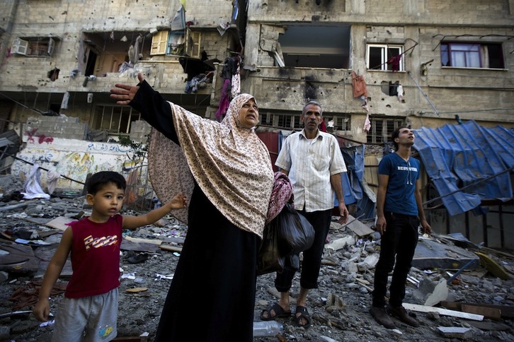 Una familia gazatí observa una zona atacada por Israel tras un bombardeo. (Mohammed ABED/AFP)