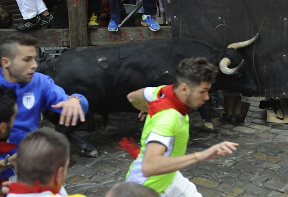 Un toro golpea el tablado situado en la esquina entre Mercaderes y Estafeta. (Ander GILLENEA/AFP PHOTO)