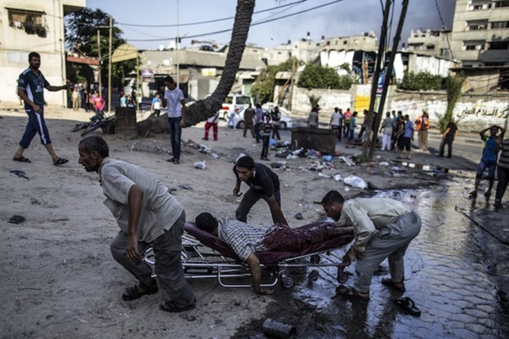 Vecinos de Gaza trasladan a uno de los heridos por el Ejército israelí. (Marco LONGARI/AFP PHOTO)