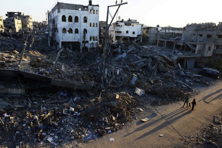 Una familia pasea por las destrozadas calles de Gaza. (Roberto SCHMIDT / AFP) 