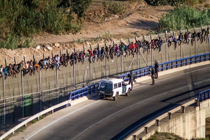 Inmigrantes encaramados ayer martes a la valla de Melilla. (@prodeinorg)