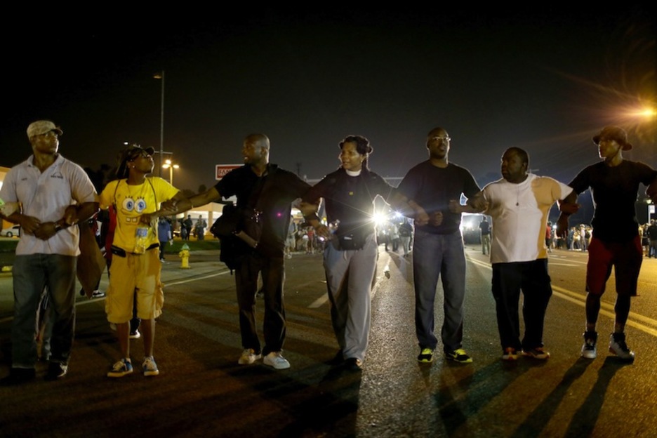 Manifestantes forman una cadena humana ante la presencia policial. (Scott OLSON / AFP)