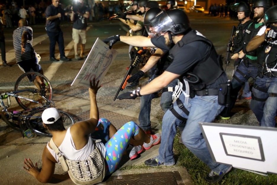Detención de otra manifestante, a la derecha requirimiento de acreditación a los medios. (Joe RAEDLE / AFP)