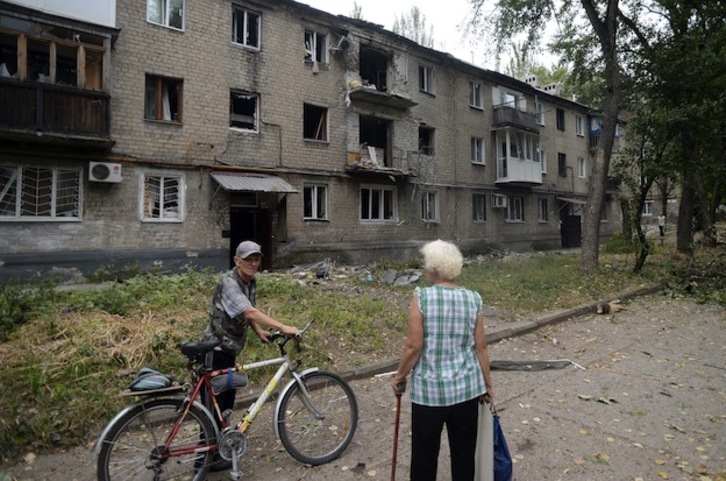 Dos residentes de Donetsk ante viviendas afectadas por la artillería. (Francisco LEONG / AFP PHOTO)