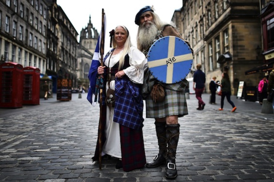 Dos personas, ataviadas con ropas típicas de las Highlands escocesas, con mensajes por el «sí» en Edimburgo. (Ben STANSALL/AFP PHOTO)
