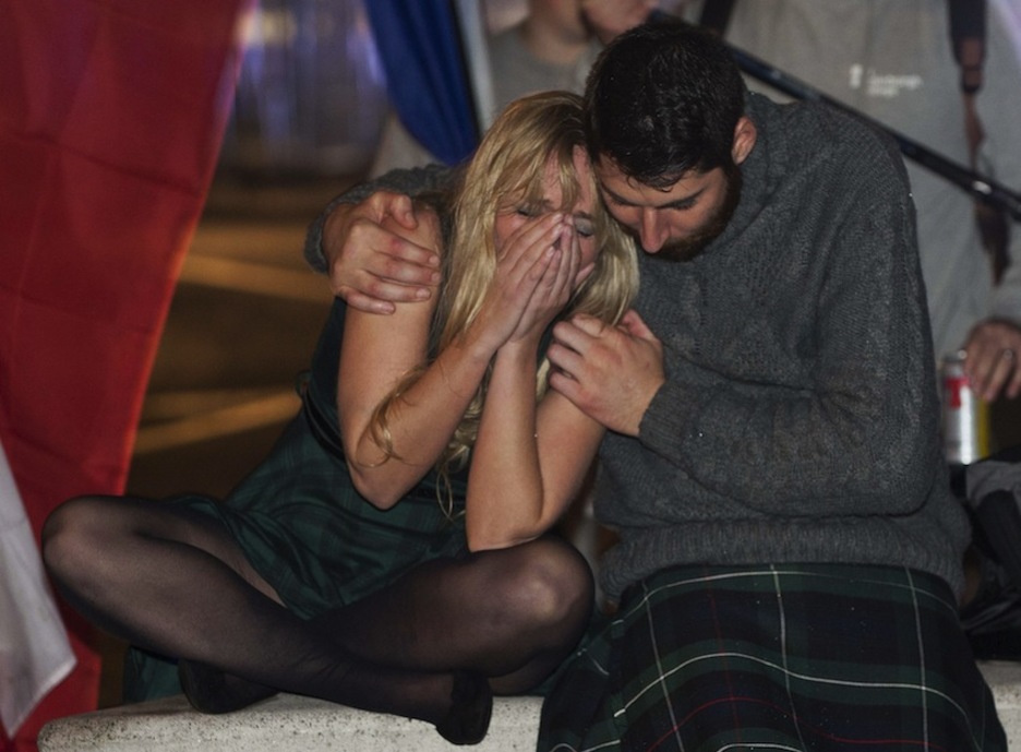 Una pareja llora tras conocerse que Escocia no ha optado por la independencia. (Lesley MARTIN/AFP)
