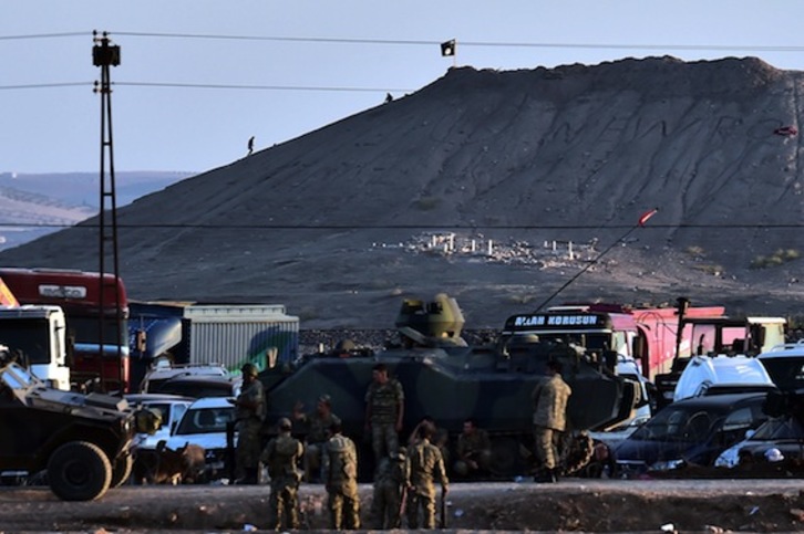Integrantes del EI colocan su bandera en una colina de Kobane. (Aris MESSINIS/AFP PHOTO)