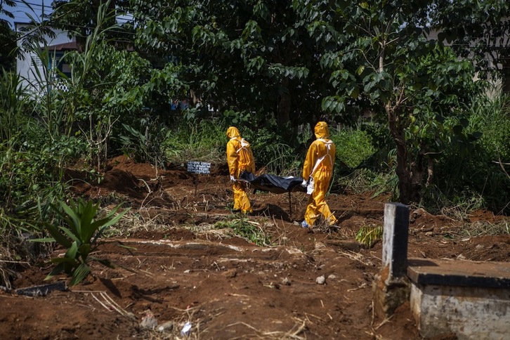 Dos operarios entierran el cuerpo de una persona contagiada por ébola en Sierra Leona. (Florian PLAUCHEUR/AFP)