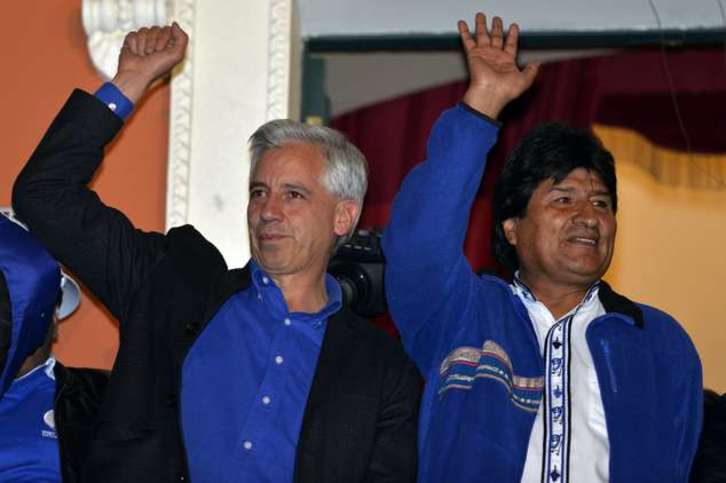 Evo Morales, a la derecha, saluda a sus seguidores acompañado del vicepresidente, Álvaro García. (Cris BOUONCLE/AFP)