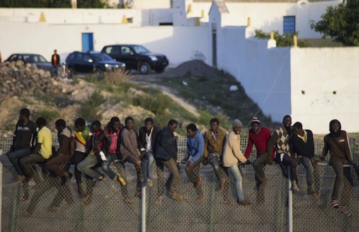 Inmigrantes encaramados este miércoles a la valla de Melilla. (Blasco AVELLANEDA / AFP)