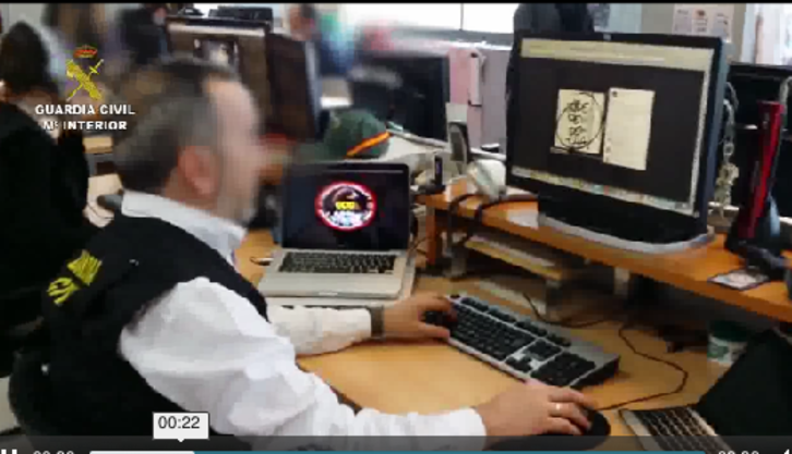 Un guardia civil observa en la pantalla un logo por la independencia. (Captura del vídeo difundido por Interior español)