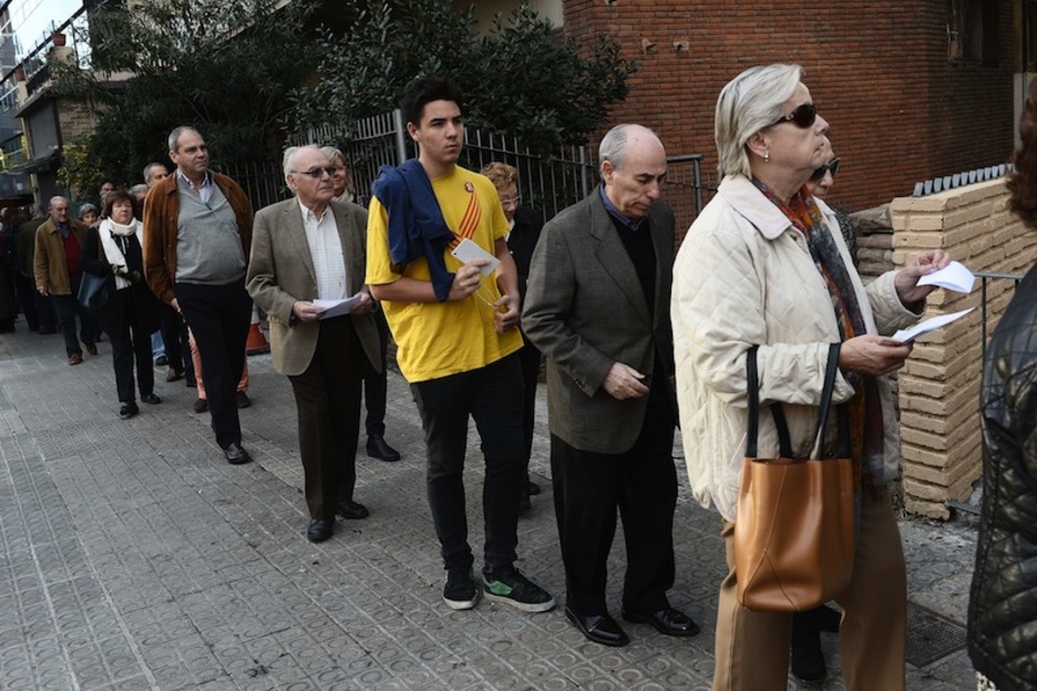 Jóvenes y mayores, todos esperan para votar. (Josep LAGO/AFP)
