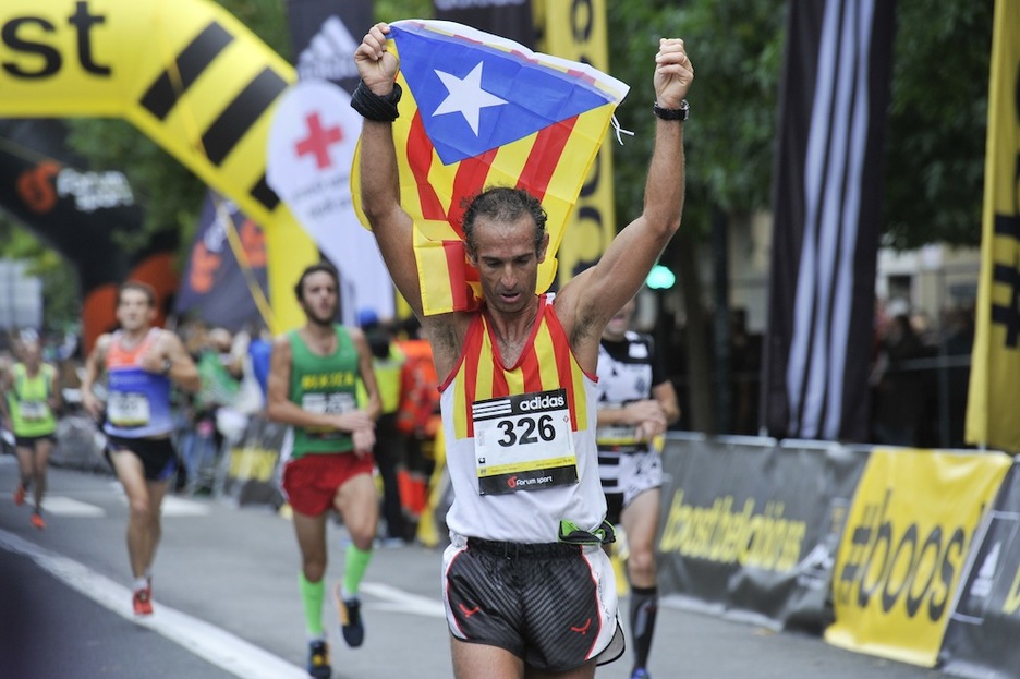 Un corredor catalán entra en meta con la senyera. (Idoia ZABALETA/ARGAZKI PRESS)