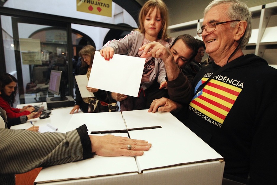 Un hombre vota con su hija en Perpinyà, Catalunya norte. (Raymond ROIG/AFP) 