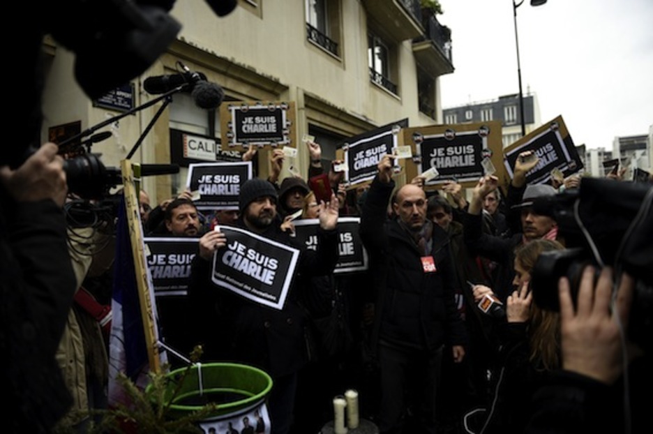 Periodistas sostienen sus acreditaciones durante el minuto de silencio en memoria de los fallecidos en el atentado contra ‘Charlie Hebdo’. (Martin BUREAU/AFP PHOTO)