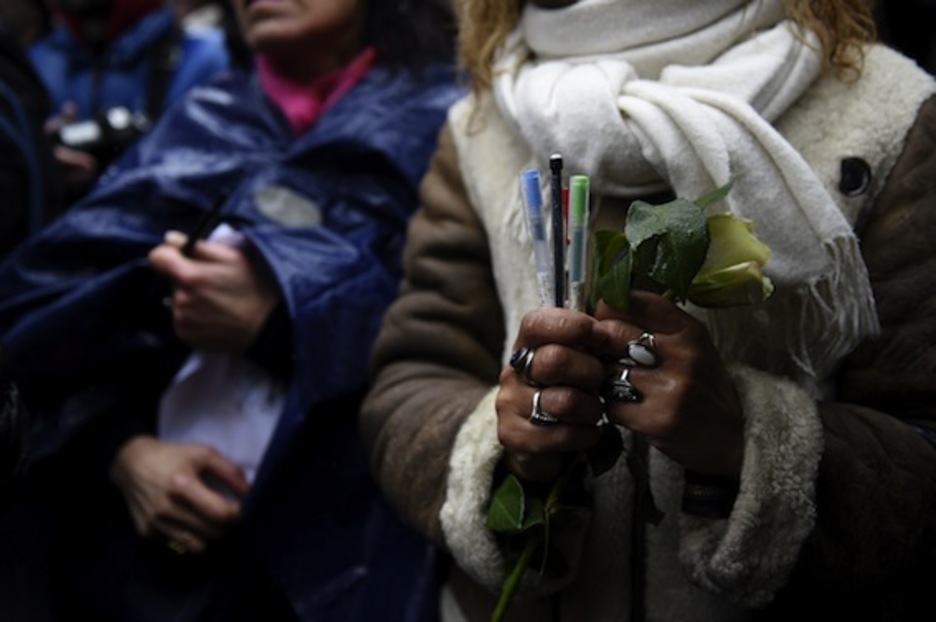 Flores y lápices en señal de recuerdo. (Martin BUREAU/AFP PHOTO)