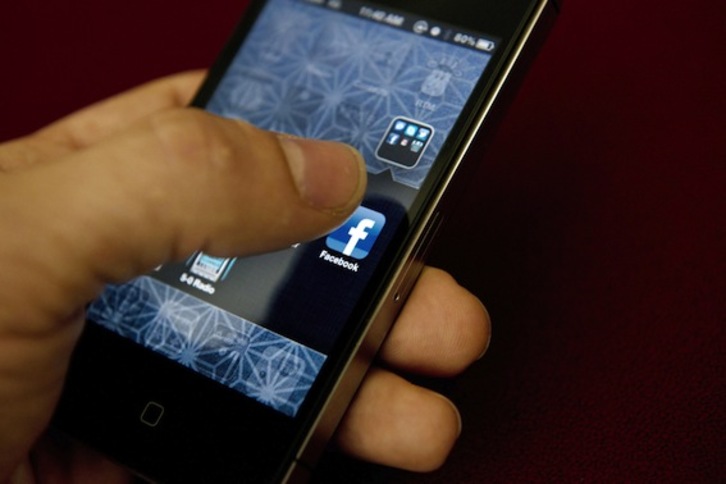 Un hombre accede a Facebook desde su dispositivo móvil. (Brendan SMIALOWSKI/AFP PHOTO)