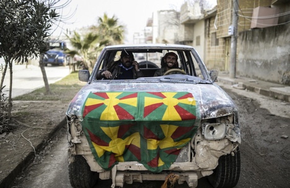 Dos kurdos, sonrientes, conducen por Kobane. (Bulent KILIC/AFP PHOTO)