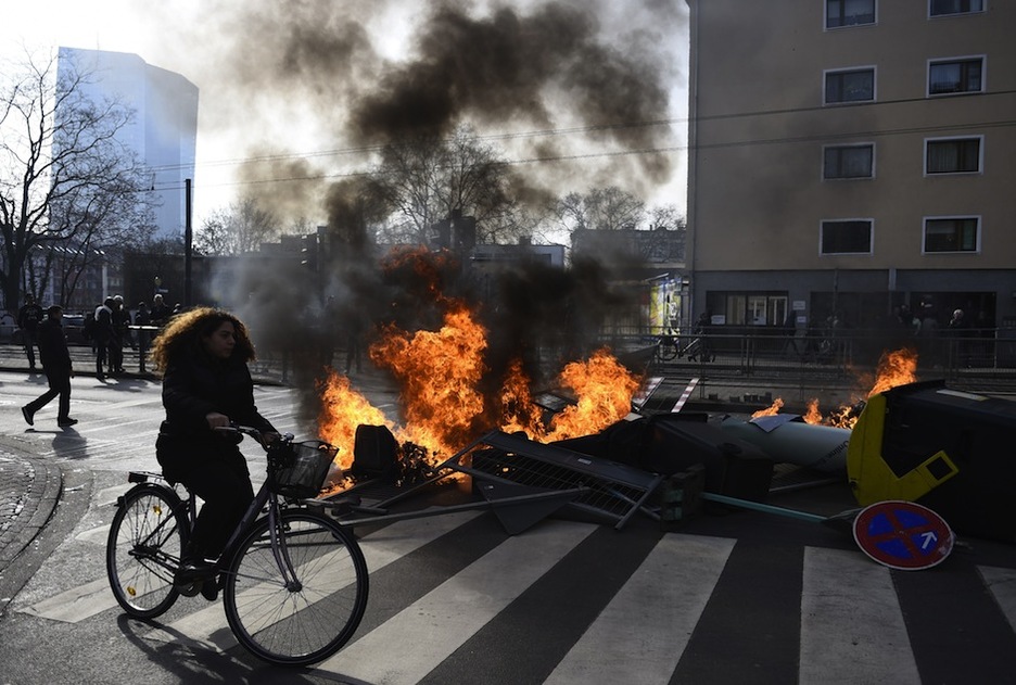 Una joven en bici pasa al lado de una de las barricadas. (Odd ANDERSEN / AFP)