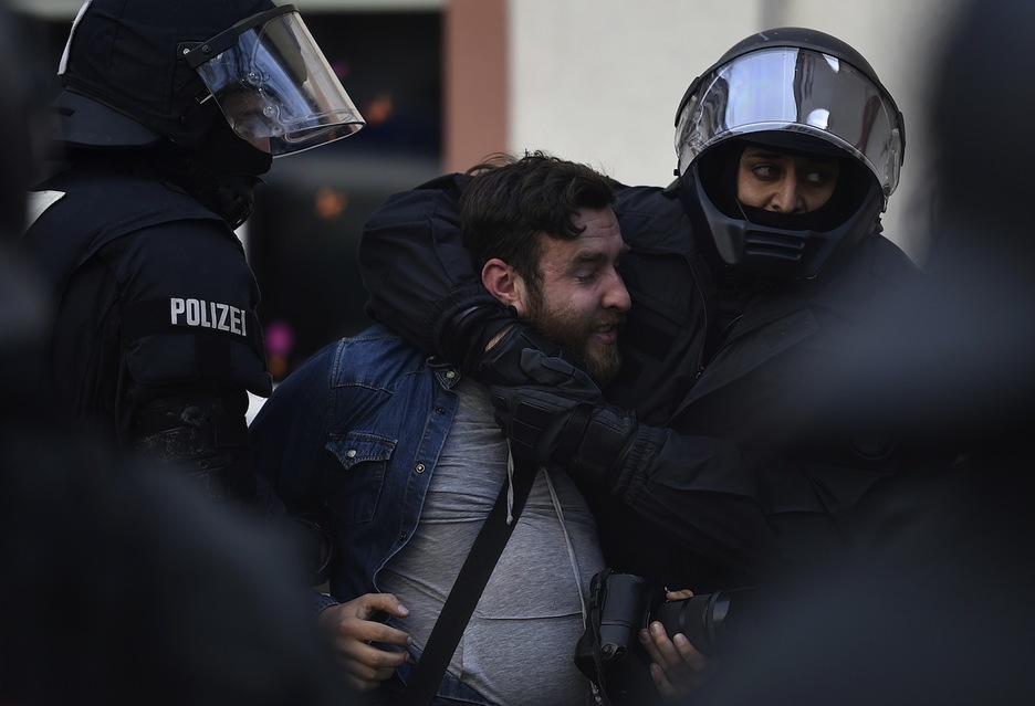 La Policía en el momento de llevarse a un fotógrafo. (Odd ANDERSEN / AFP)