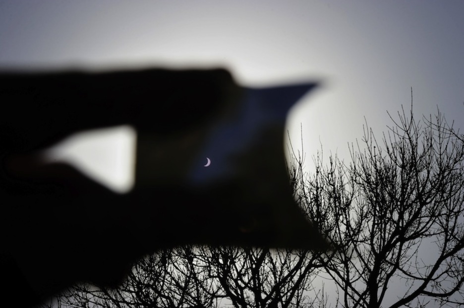 Una persona usa una diapositiva para ver el eclipse. (Miguel RIOPA/AFP)