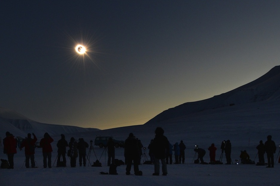 Personas viendo el eclipse en Longyearbyen, el mayor archipiélago de las Islas Svalbard, pertenecientes a Noruega. (Stan HONDA/AFP)