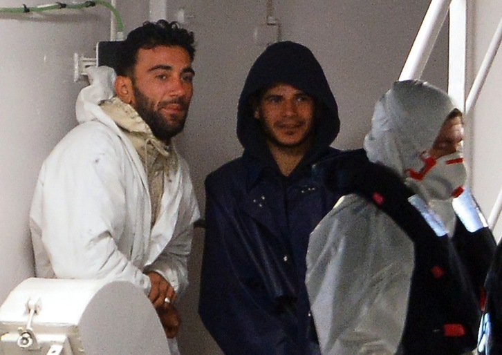 Mohamed Ali Malek, capitán del barco, y Mahmud Bikh, tripulante, en un barco de la guardia costera italiana antes de ser encarcelados. (Alberto PIZZOLI/AFP)
