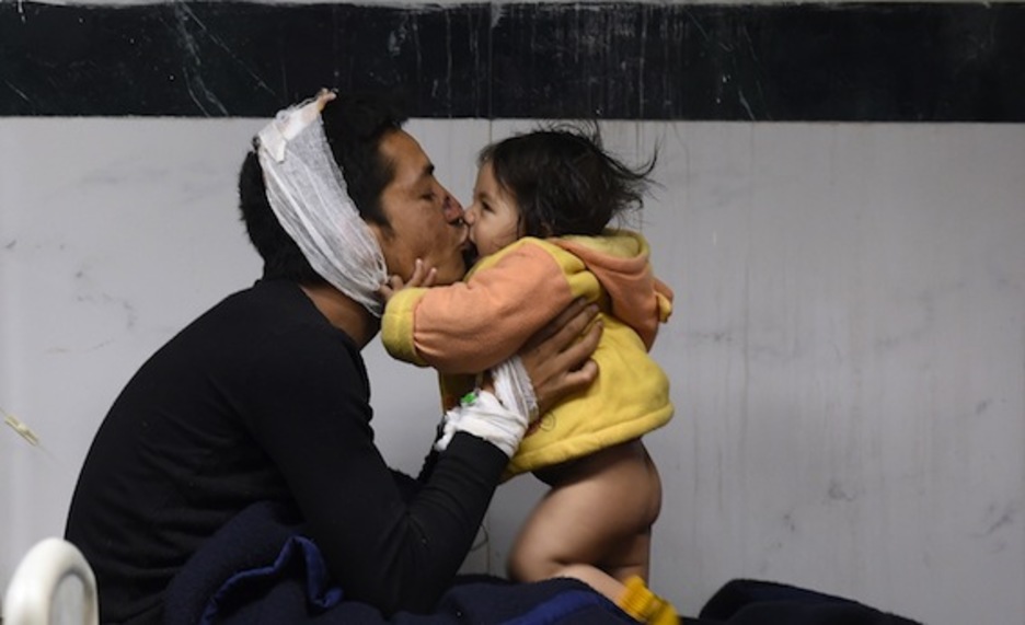 Un padre besa a su hija de 8 meses en un hospital de Katmandú. (Prakash SINGH/AFP PHOTO)