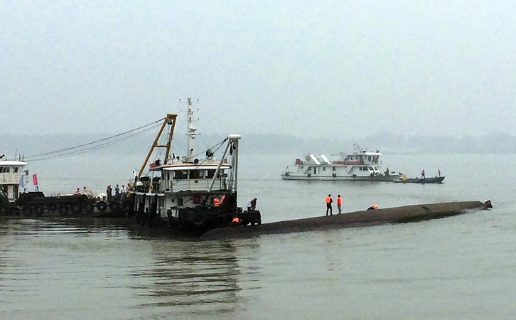 Equipos de rescate sobre la quilla del barco. (STR / AFP)