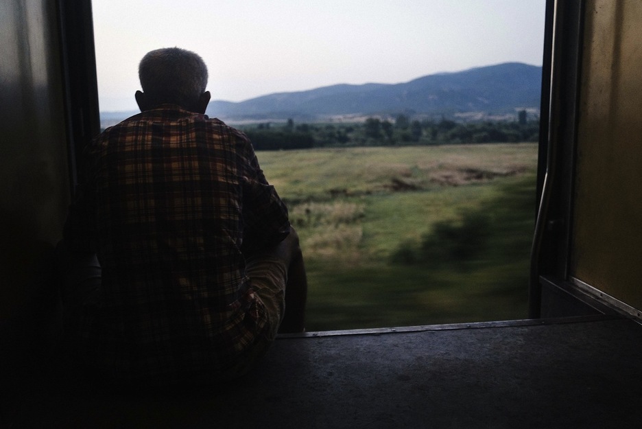 Un hombre observa el paisaje en el tren que le lleva a Serbia. (Dimitar DILKOFF/AFP)