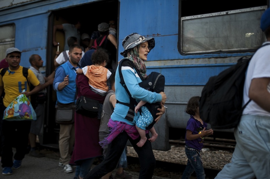 Un grupo de personas se apresuran a tomar el tren. (Robert ATANASOVSKI/AFP)