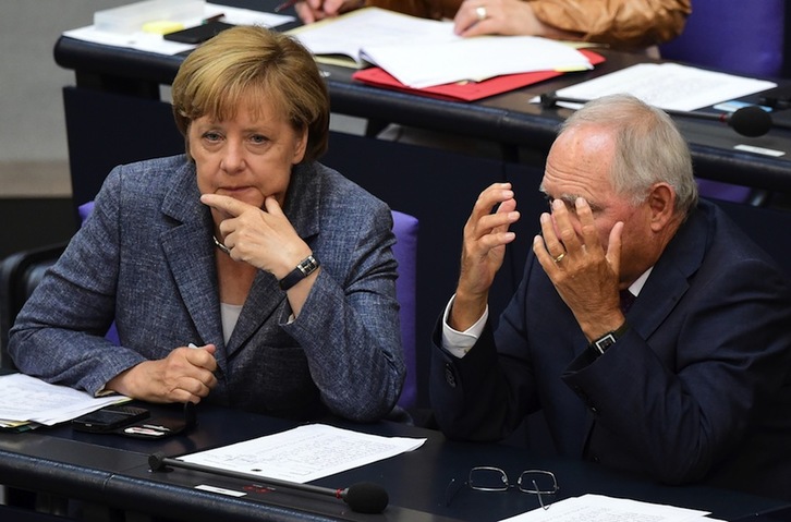 Angela Merkel habla con el ministro Wolfgang Schäuble durante el debate. (John MACDOUGALL/AFP)