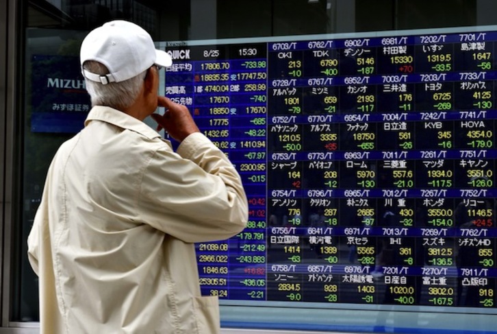 Un hombre contempla las cotizaciones de la Bolsa de Tokio. (YOSHIKAZU TSUNO / AFP)