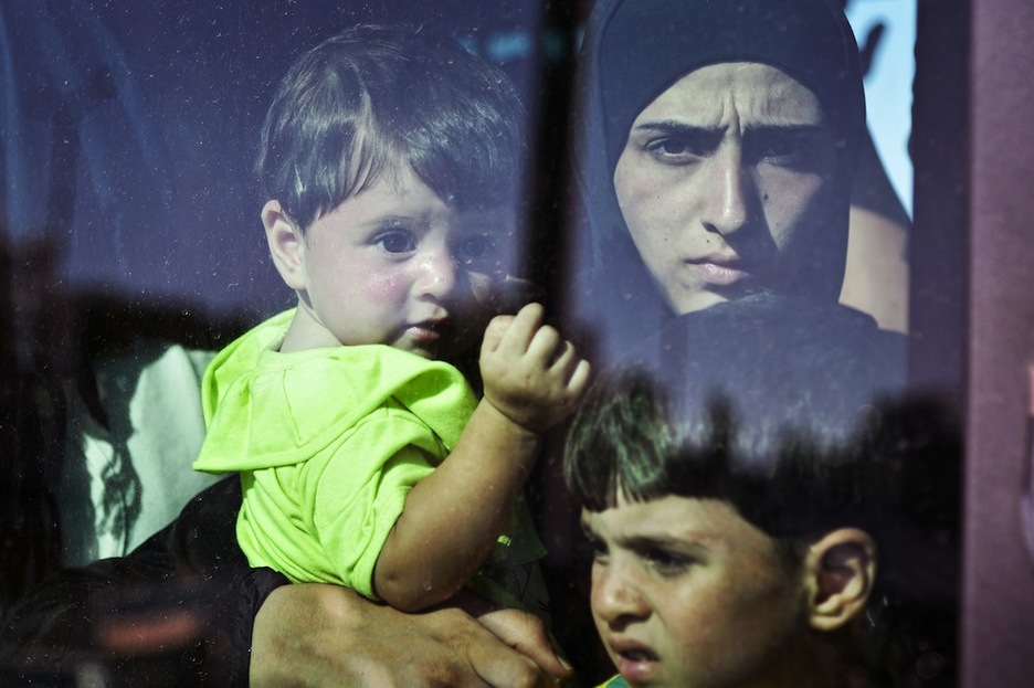 Errefuxiatu familia bat Atenaseko autobusean. (Louisa GOULIAMAKI/AFP)