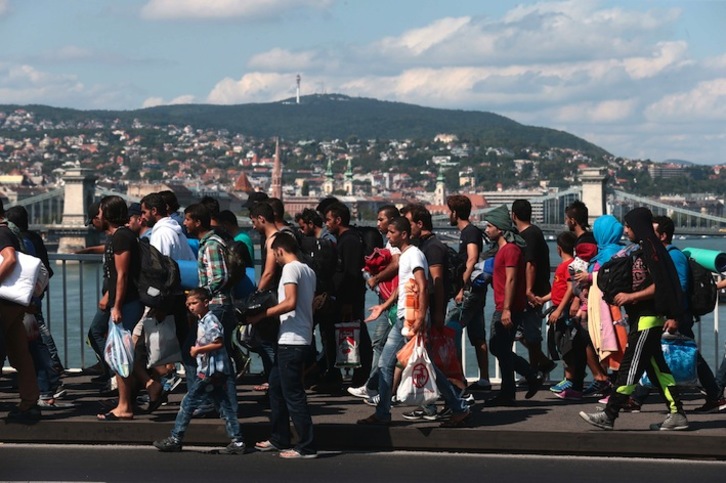 Cientos de refugiados caminan por Budapest tras escapar de la estación de tren en la que estaban atrapados. (Ferenc ISZA/AFP) 