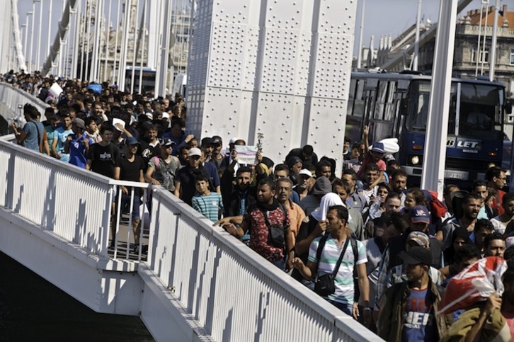 Decenas de refugiados caminan por Budapest tras dejar la estación. (Peter KOHALMI/AFP) 