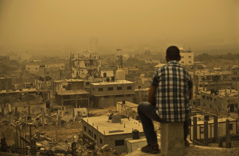 Un palestino ante la tormenta de arena y una Gaza destruida. (Mohammed ABAD / AFP)