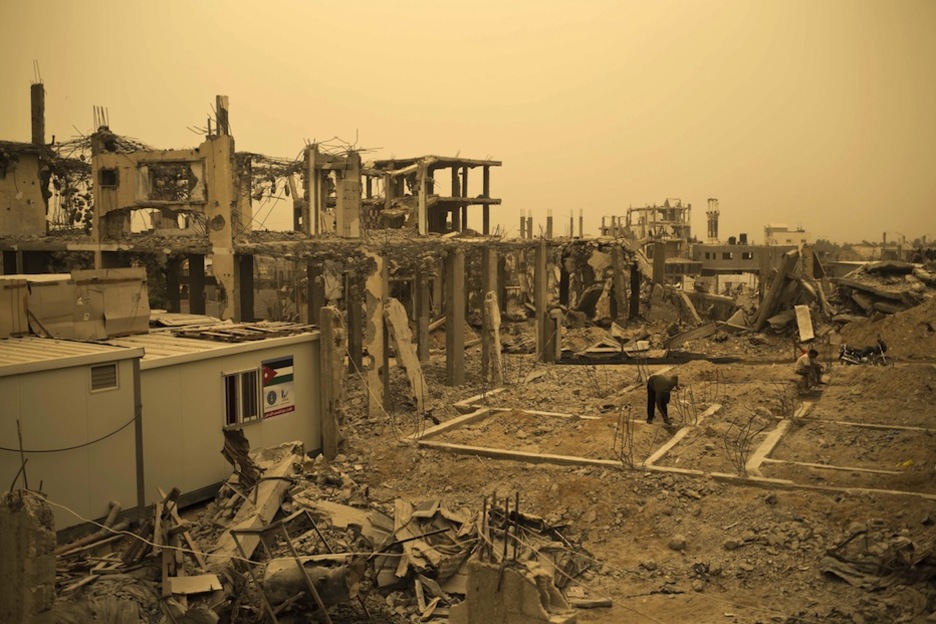 Palestinos trabajan en la reconstrucción de lo que dejó el ataque israelí. (Mohammed ABAD / AFP)