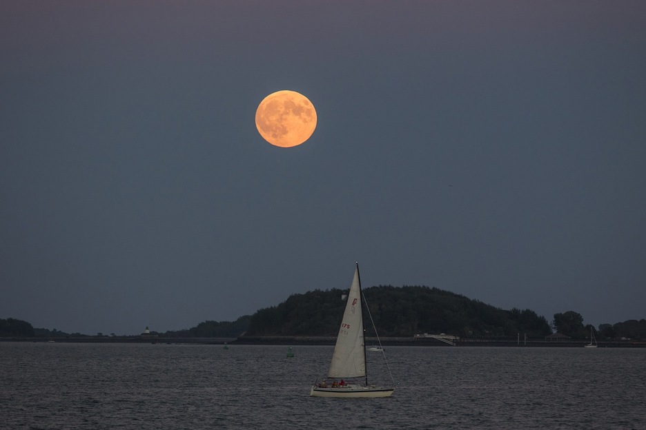 La superluna se eleva sobre un velero en Boston. (Scott EISEN/AFP) 