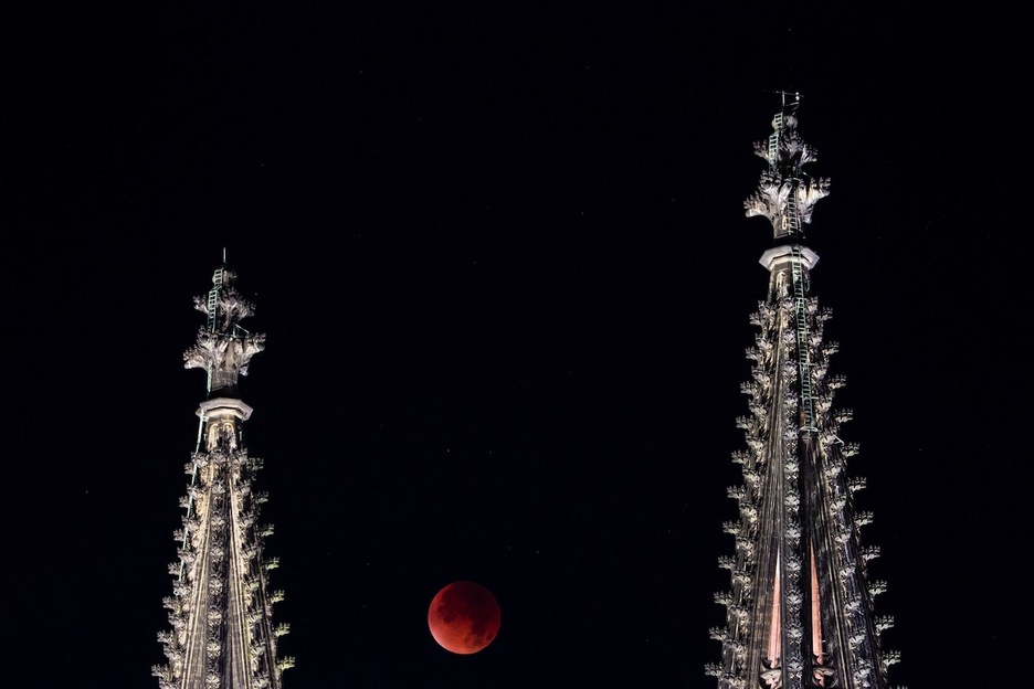 La luna asomándose entre las torres de la catedral de Colonia. (Rolf VENNENBERND/AFP) 